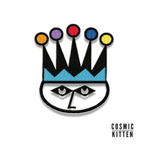 May include: Black and white embroidered patch of a face with a crown. The crown has five colorful gems: orange, purple, red, blue, and yellow.