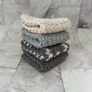 Peut inclure: Un lot de quatre torchons en crochet dans des tons de gris et de blanc. Les torchons sont faits de fil de coton et ont une surface texturée.