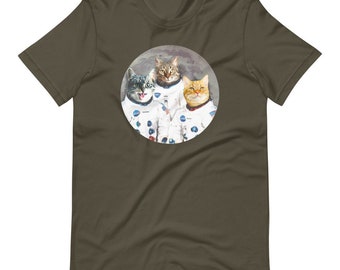 May include: A dark green t-shirt with a circular image of three cats dressed as astronauts on the moon. The cats are wearing white spacesuits with NASA patches. The image is surrounded by a white circle.
