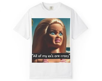 May include: White t-shirt featuring a graphic of a Barbie doll with an angry expression. The text "All of my ex's are crazy" is displayed below the image. The shirt is a casual wear item.