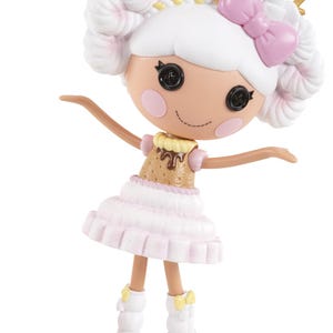 Puede incluir: Una muñeca con cabello blanco peinado en dos moños y un lazo rosa. La muñeca tiene ojos de botón y mejillas rosadas. Viste un vestido rosa y beige con una falda blanca y botas blancas con lazos amarillos. Los brazos de la muñeca están extendidos.