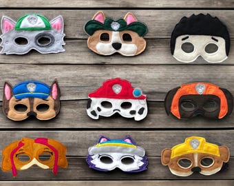 May include: A collection of nine felt masks featuring various cartoon dog characters. Each mask includes eye cutouts and distinct colours such as red, blue, yellow, green, orange, brown, white, and black, representing different canine-themed personas.