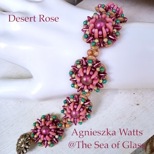 May include: A floral beaded bracelet in shades of pink, green, and gold. The bracelet's design resembles flowers. The text "Desert Rose" and "Agnieszka Watts @The Sea of Glass" are displayed on the image.