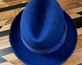 May include: A blue fedora hat with a dark blue ribbon band.