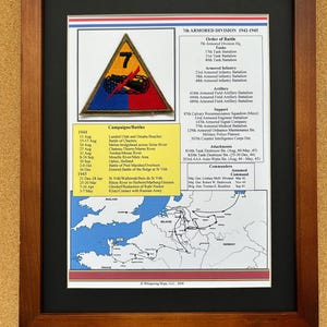 Peut inclure: Impression encadrée présentant la 7e Division Blindée 1942-1945. L'impression comprend un écusson avec un char noir sur un triangle jaune, une liste de batailles et une carte de l'Europe. Le cadre est marron foncé.
