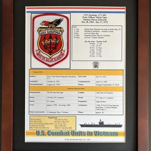 May include: Framed print of the USS Saratoga (CV-60) with a patch, text, and a ship illustration. The patch features a red, gold, and black design with the words "Invictus Gallus Gladiator". The print includes details about the ship's service.