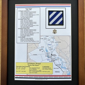 May include: Framed print featuring the 3rd Infantry Division's Operation Iraqi Freedom map and unit information. Includes a blue and white patch, a map of Iraq, and text detailing the order of battle and key dates. The frame is brown.