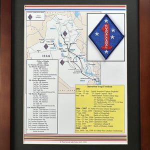 May include: Framed print featuring a map of Iraq with military operation routes and a patch. The patch is blue with a red border, the number 1, and the word "Guadalcanal". Includes text detailing the "Order of Battle" and "Operation Iraqi Freedom".