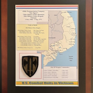 May include: Framed print of a U.S. Combat Units in Vietnam display. The print includes a map of Vietnam, unit information, and a patch with a black and gold design. The frame is dark brown.