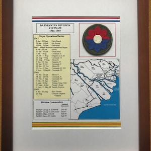 May include: Framed print of the 9th Infantry Division in Vietnam, 1966-1969. Includes a map, division patch, and a list of major operations and battles. The print is in a brown wooden frame with a white mat.