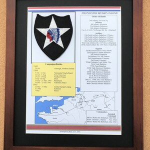 May include: Framed print of the 2nd Infantry Division 1943-1945. The print includes a patch with a white star and Native American profile, campaign dates, and a map of Europe. The frame is dark brown.