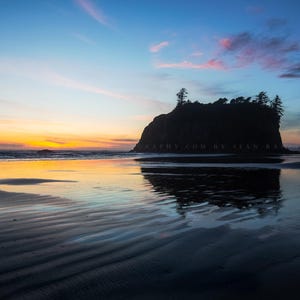 May include: A scenic landscape photograph of a beach at dusk. The sky transitions from blue to orange and pink, reflecting in the wet sand. A dark, tree-covered island is silhouetted against the horizon. The image includes text: PHOTOGRAPHY.COM BY STAN BAR.