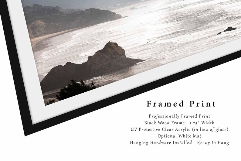 May include: A framed print of a coastal landscape with a rocky outcropping and ocean waves. The frame is black wood with a 1.25 inch width and a clear acrylic protective layer. It includes an optional white mat and hanging hardware.