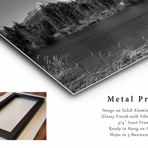 May include: Black and white photograph of a mountain lake with trees and a mountain in the background. The image is printed on a metal sheet with a glossy finish and a 3/4 inch inset frame.