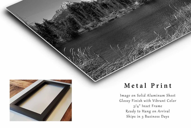 May include: Black and white photograph of a mountain lake with trees and a mountain in the background. The image is printed on a metal sheet with a glossy finish and a 3/4 inch inset frame.