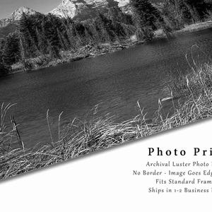 May include: Black and white photograph of a mountain lake with trees and mountains in the background. The image is printed on archival lustre photo paper with no border. The image goes edge to edge and fits standard frames. Ships in 1-2 business days.