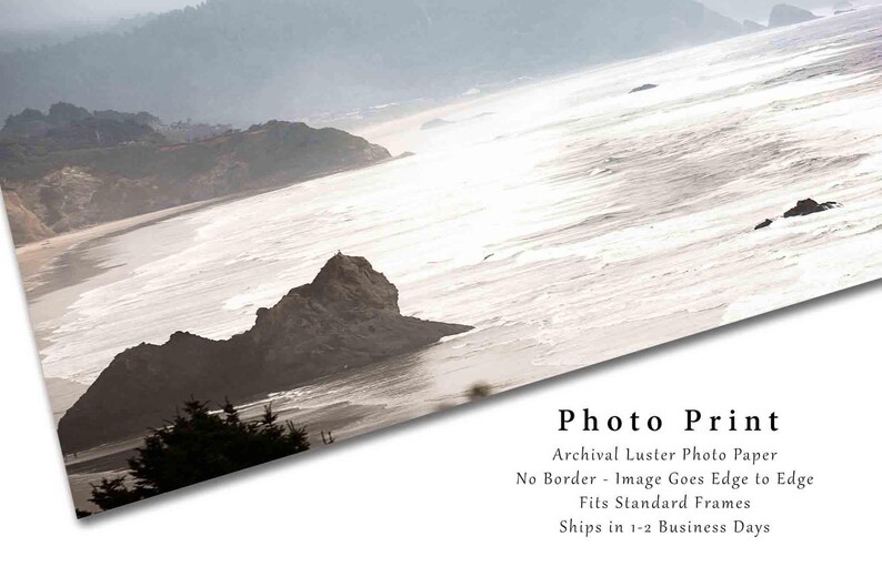 May include: A photo print of a misty seascape with a rocky coastline and a beach. The image is printed on archival luster photo paper with no border, and the image goes edge to edge. The print is suitable for standard frames and ships in 1-2 business days.