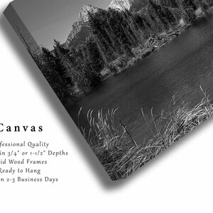 May include: Black and white photograph of a mountain lake with trees and snow-capped mountains in the background. The image is printed on canvas and ready to hang.