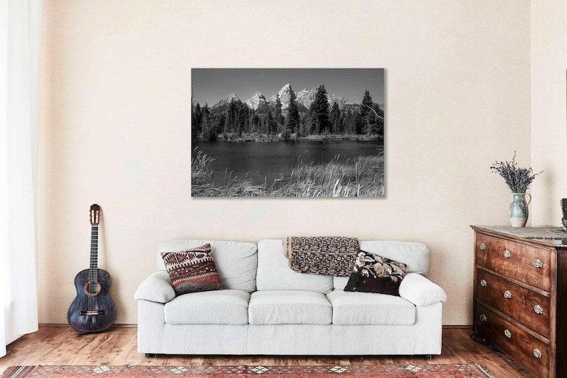 May include: Black and white photograph of a mountain range reflected in a still lake. The mountains are covered in snow and the lake is surrounded by trees.