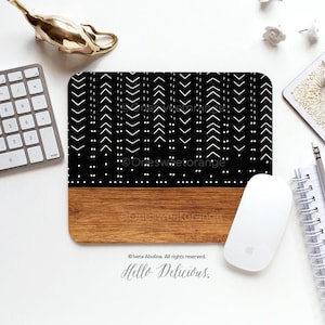 May include: Black and white geometric patterned mouse mat with a wood base. The mouse mat has a white border and the text "Hello Delicious." is printed below the base.