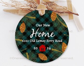 May include: A round, green and black plaid ornament with a pine bough and pine cone design. The ornament says "Our New Home" and "6101 Old Lemay Ferry Road". There is a small red house icon with the numbers 20 and 24.