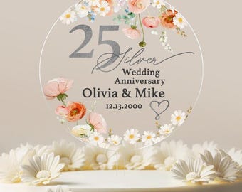 May include: A round cake topper with a floral design and the text "25 Silver Wedding Anniversary Olivia & Mike 12.13.2000".