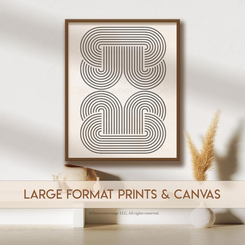 May include: A framed print with a geometric design of overlapping, concentric circles in shades of gray. The print is set against a white wall with a decorative vase and a plant in the foreground. The text "LARGE FORMAT PRINTS & CANVAS" is displayed at the bottom of the image.