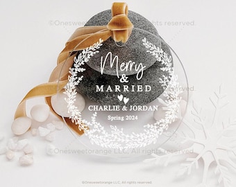 May include: A clear round ornament with a white wreath design and the text "Merry & Married Charlie & Jordan Spring 2024".