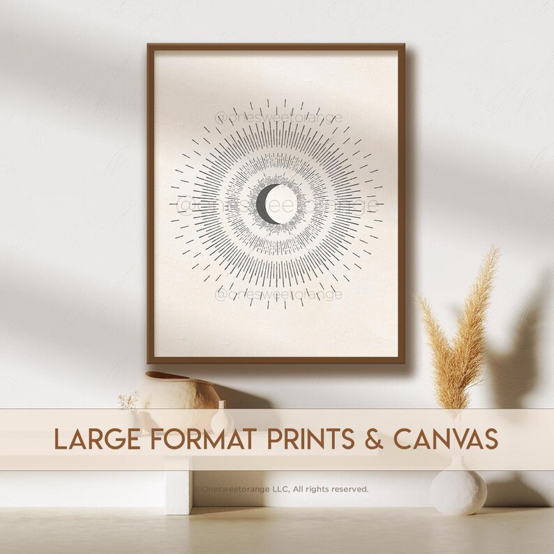 May include: A framed print of a moon phase calendar with a crescent moon in the center and a sunburst design. The print is on a beige background with a brown frame. The text "@greyscaleorange" is at the bottom of the print.