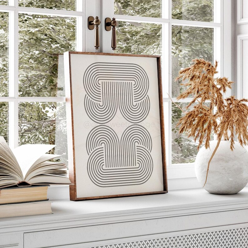 May include: A framed print with a black and white geometric design of overlapping arches. The design is reminiscent of a modern art style.