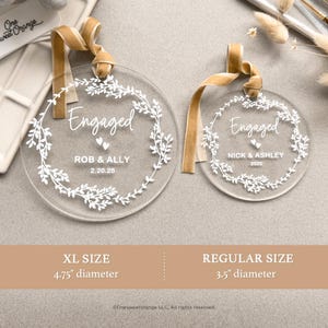 two clear acrylic tags with a gold ribbon