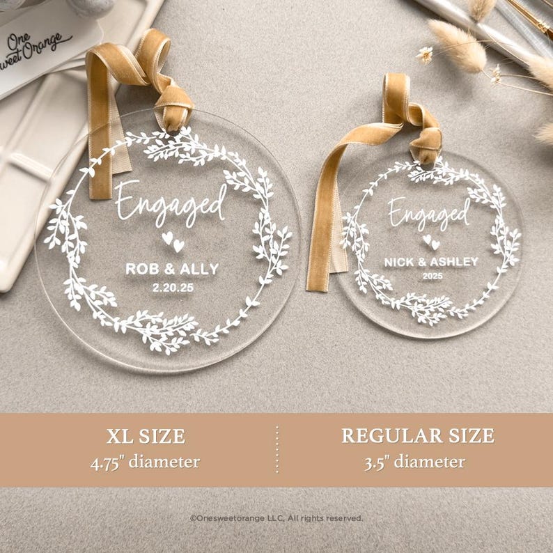 two clear acrylic tags with a gold ribbon