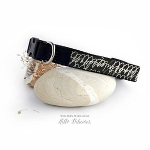 May include: Black dog collar with a white abstract pattern and the text "Hello Delicious".
