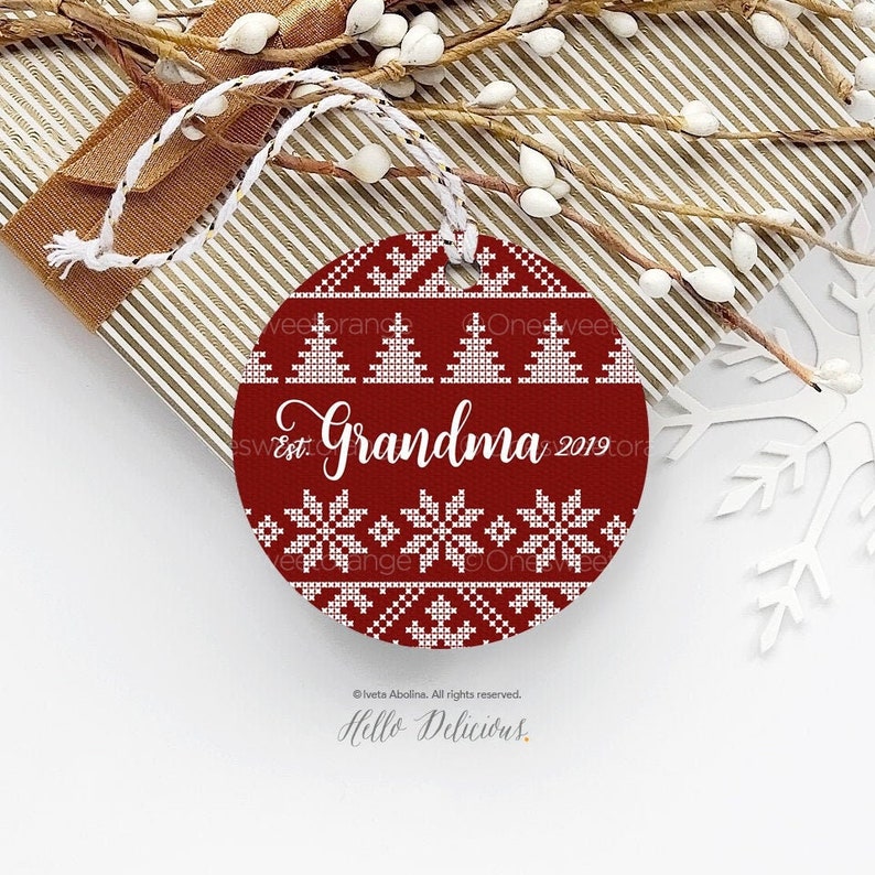 May include: Red round Christmas ornament with a white Scandinavian-style pattern. The ornament has the text "Est. Grandma 2019" in white.