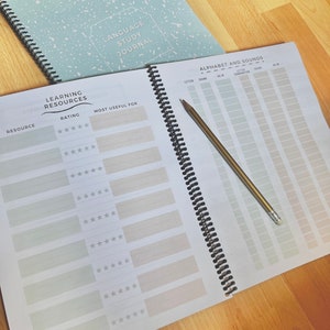 May include: A spiral bound journal with a light blue cover with white speckles. The cover has the text "Language Study Journal". The journal has a section for rating learning resources and a section for tracking alphabet and sounds.