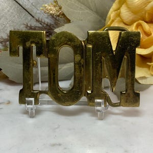 Brass Tom Belt Buckle 1980s Astamar