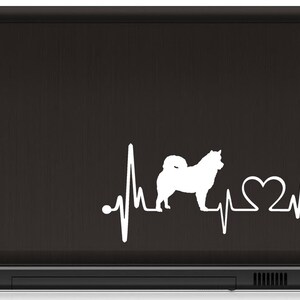 May include: White silhouette of a dog with a heartbeat line and a heart symbol. The design is on a black laptop.