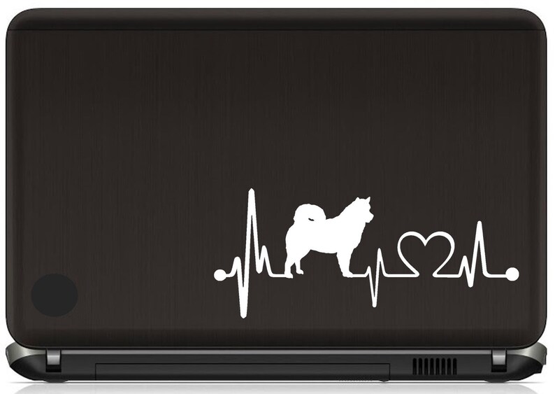 May include: White silhouette of a dog with a heartbeat line and a heart symbol. The design is on a black laptop.