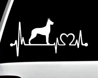 Puede incluir: Silueta blanca de un perro Doberman Pinscher con un gráfico de latido del corazón y corazón. El gráfico está sobre un fondo negro.