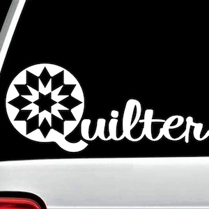 May include: White vinyl decal with a stylized starburst design and the word "quilter" in a cursive font.