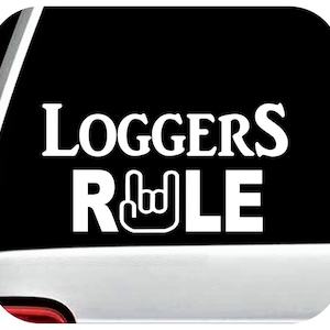 May include: White vinyl decal with the text "Loggers Rule" in a bold font. The word "Rule" has a rock and roll hand gesture symbol in place of the letter "U".