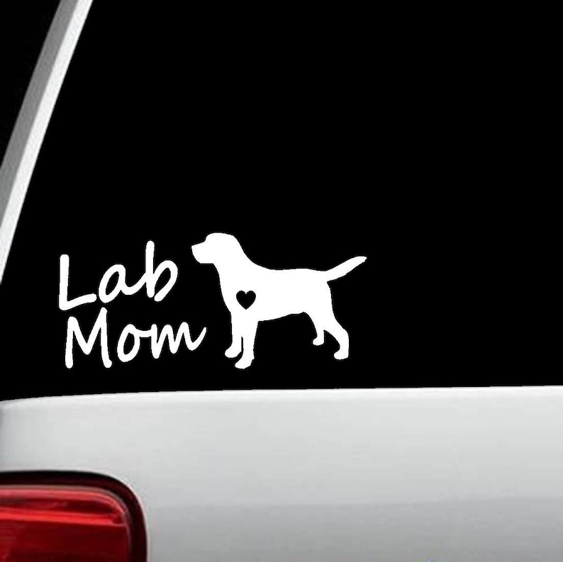 May include: White vinyl decal with a silhouette of a Labrador Retriever with a heart on its chest and the text "Lab Mom" in a handwritten font.