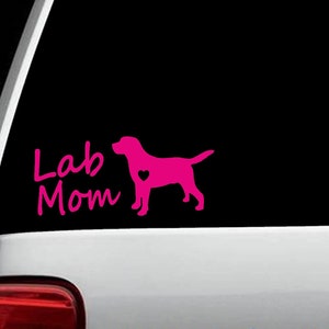 May include: Pink vinyl decal with a silhouette of a Labrador Retriever with a heart on its chest and the text "Lab Mom" in a cursive font.