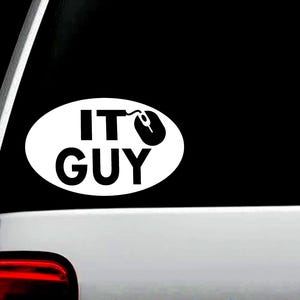May include: White oval sticker with the words "IT GUY" in bold black letters. A black computer mouse graphic replaces the letter "O". The sticker is displayed on a vehicle window.