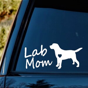 May include: White vinyl decal with the text "Lab Mom" and a silhouette of a Labrador Retriever with a heart on its chest.