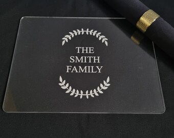 May include: A clear acrylic serving tray with a white engraved design. The design features a wreath of leaves surrounding the text "THE SMITH FAMILY".