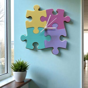 Può includere: Un orologio da parete colorato a forma di puzzle, con quattro pezzi ad incastro in giallo, turchese, viola e rosa. L'orologio ha le lancette bianche ed è montato su una parete azzurra. Una piccola pianta in vaso è su un davanzale.
