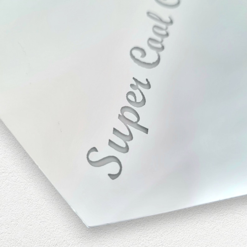 May include: Close-up of a white surface with the text "Super Cool" written in a cursive font.
