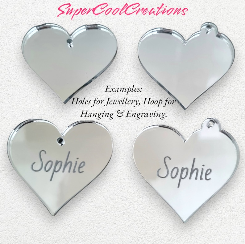 May include: Four silver mirror heart-shaped ornaments. Two of the hearts have the name "Sophie" engraved on them. The text "Examples: Holes for Jewellery, Hoop for Hanging & Engraving." is printed below the ornaments.