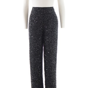 Puede incluir: Pantal&oacute;n negro de lentejuelas con cintura alta. El pantal&oacute;n est&aacute; hecho de una tela suave y fluida y est&aacute; adornado con peque&ntilde;as lentejuelas que crean un efecto brillante.